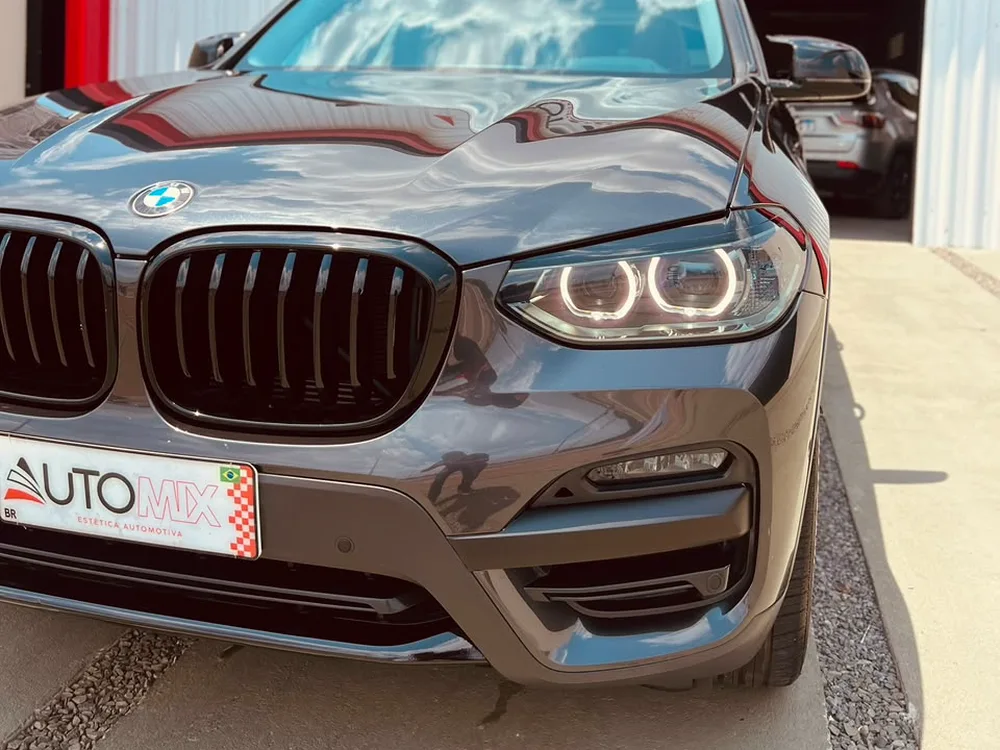 BMW X3 preta com a pintura refletindo a fachada da AUTOMIX